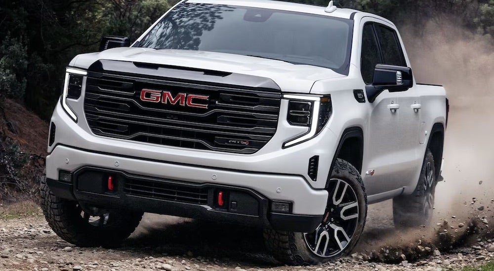 A white 2024 GMC Sierra 1500 AT4 off-roading.