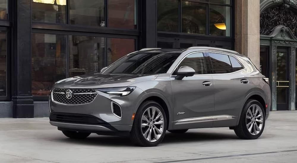 A gray 2023 Buick Envision parked near glass windows.