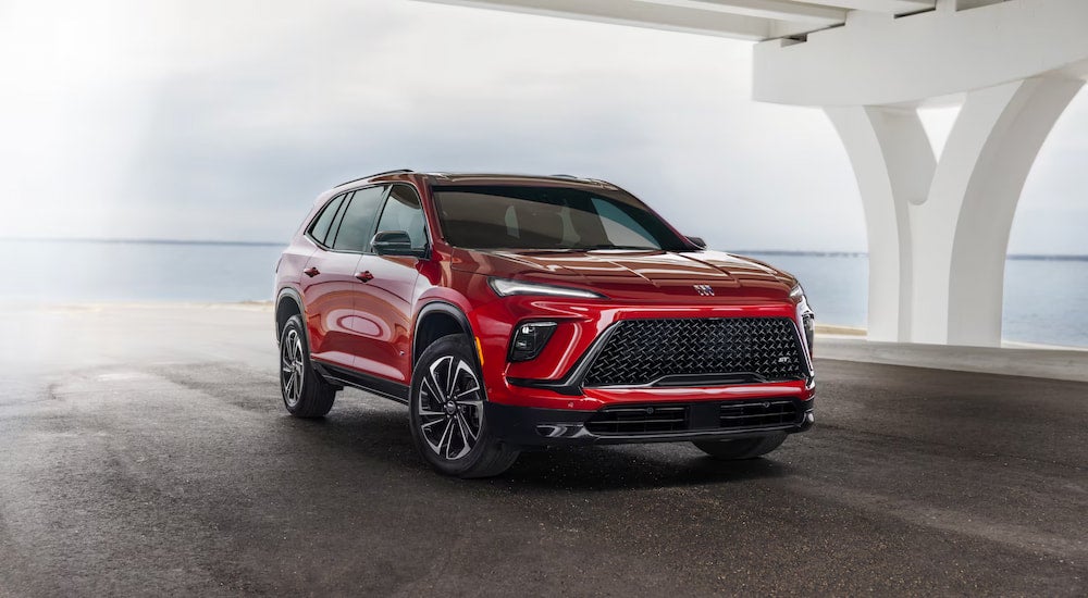 A red 2025 Buick Enclave parked near water.