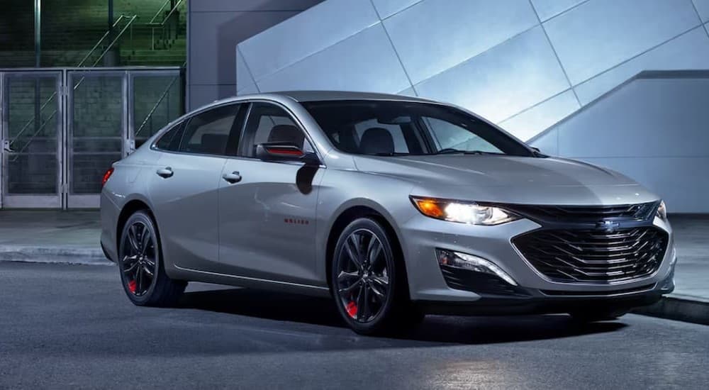 A silver 2024 Chevy Malibu 1LT parked in a city.