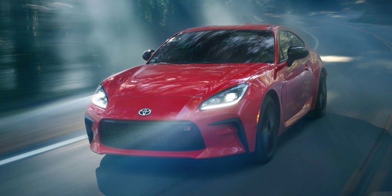 A 2024 Toyota GR86 driving with its headlights on in Kent, OH