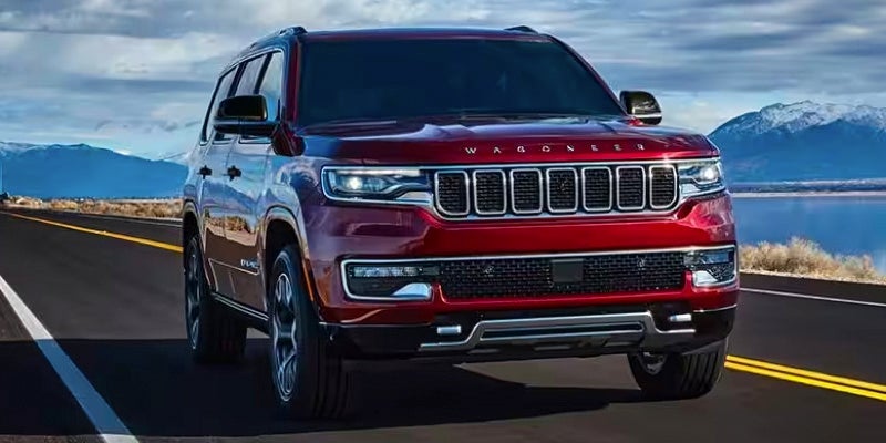 A red 2024 Wagoneer driving down the open highway.