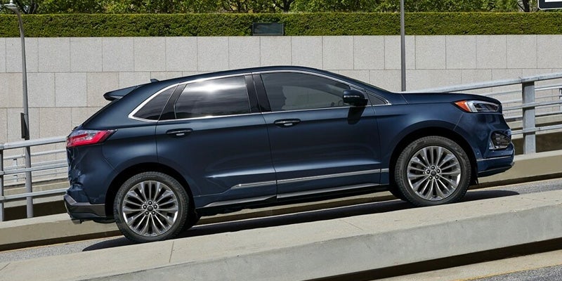 A photo of a dark blue 2024 Ford Edge parked on a hill
