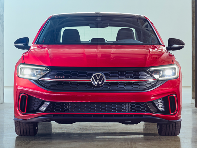 A red 40th Anniversary Volkswagen Jetta GLI facing the camera on the showroom floor.