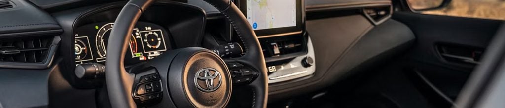 2026 Toyota vehicle interior showcasing the steering wheel, digital dashboard, and modern infotainment display.