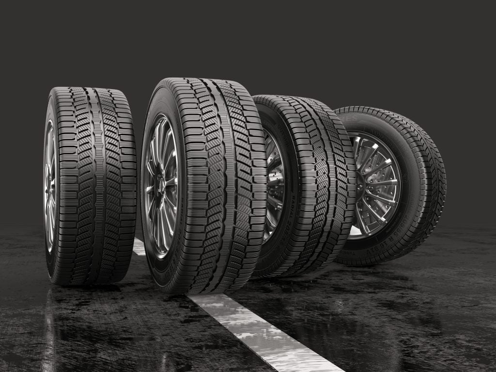 Four car tires mounted to wheels