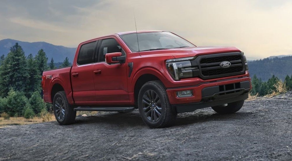 Red 2024 Ford F-150 parked off-road on a hill.
