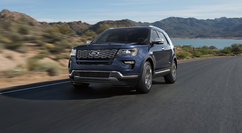 Blue 2018 Ford Explorer driving away from a lake.