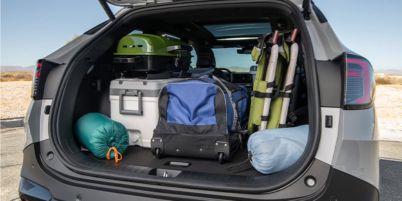 The pack of a Kia vehicle filled with camping equipment.
