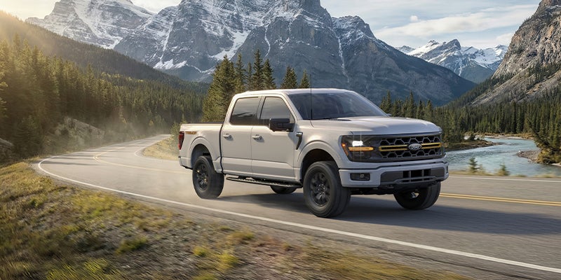 A white Ford F-150 pickup truck on the road.
