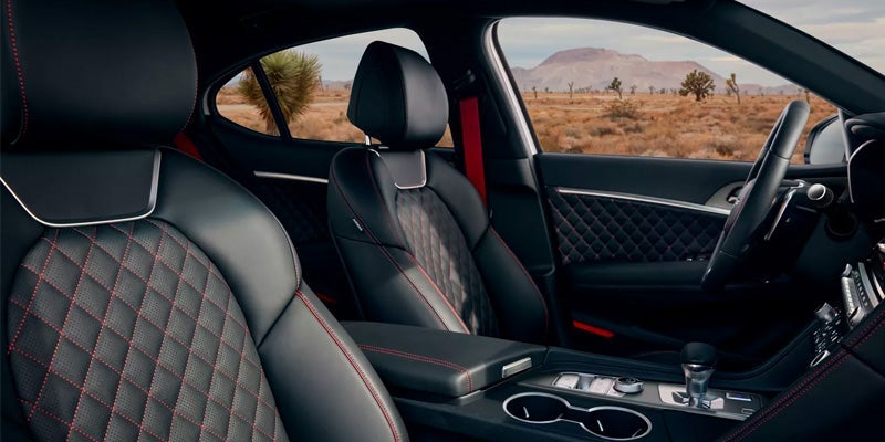 The interior of an all-new 2024 Genesis G70. Black leather with red stitching. - Genesis of Baton Rouge Dealership