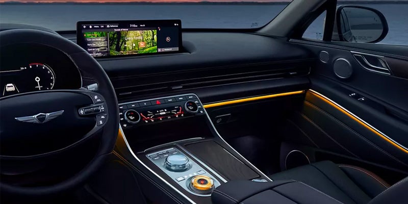Black interior with yellow accent lights in the front seat and dash area of an all-new Genesis GV80. - Genesis of Baton Rouge, LA