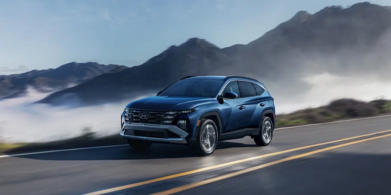A Hyundai Tucson SUV driving through mountain roads.