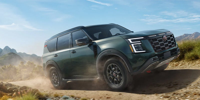 A Nissan Armada leaving a trail of dust behind it driving off-road.