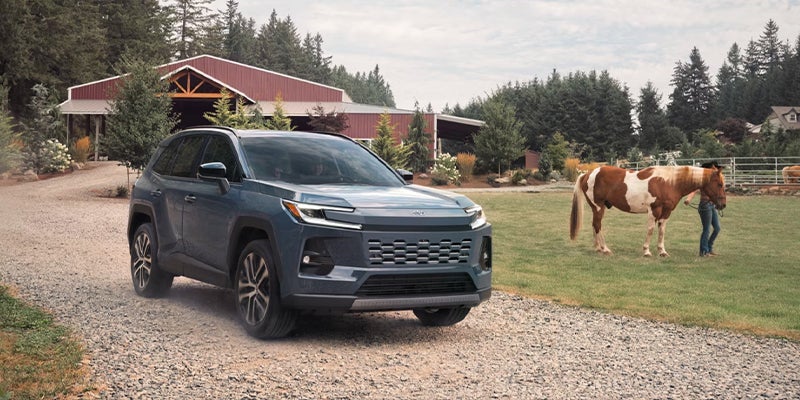 A dark grey Toyota RAV4 parked at a farm.