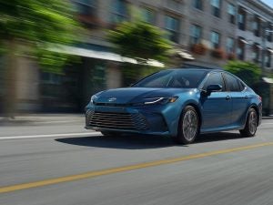 2026 Toyota Camry Hybrid driving through the city.