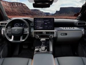 Toyota Tacoma interior showing steering wheel, dash and screen.