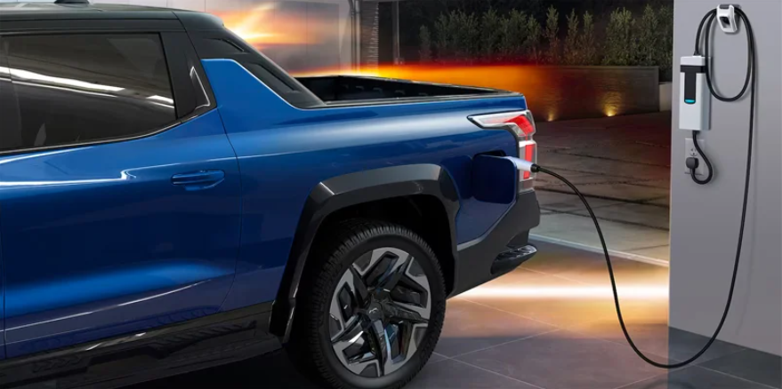 A blue Chevy Silverado EV charging near Commonwealth Chevrolet.