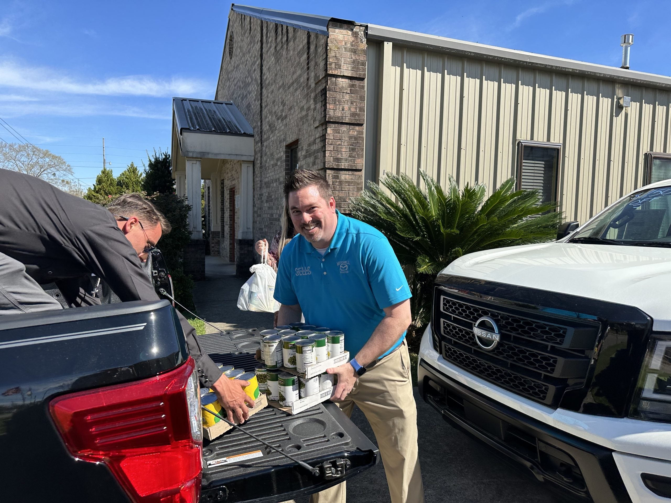 Jonathan with Mitchell Mazda unloading food drive donations at the Christian Mission
