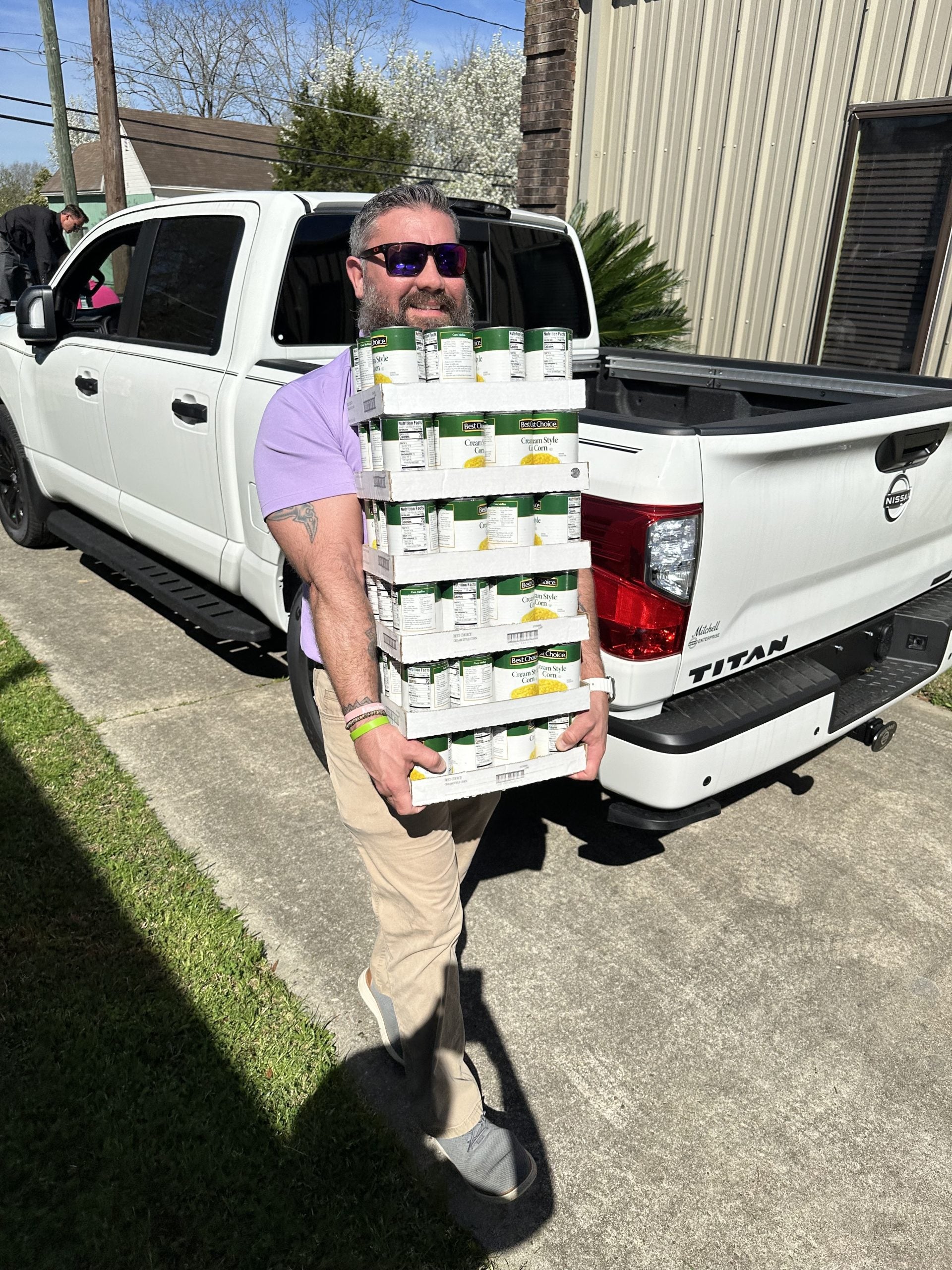 Ryan with Mitchell Nissan unloading food drive donations at the Christian Mission