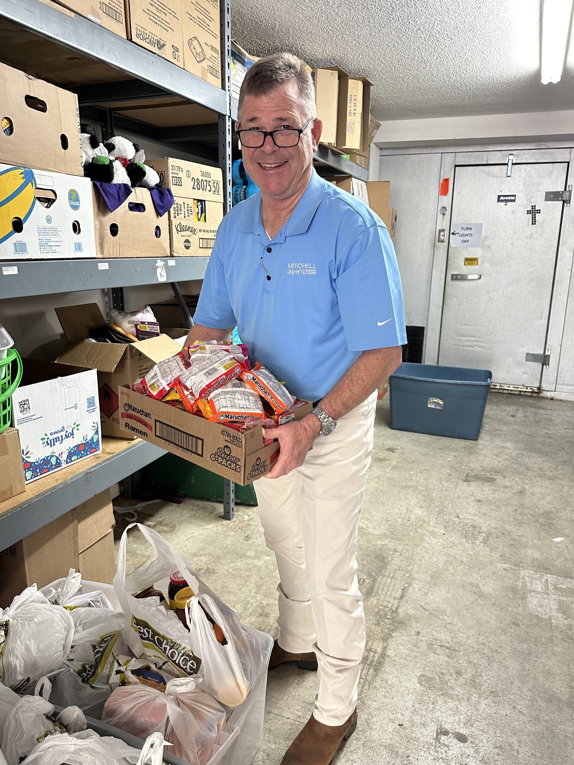 Fred Sneed with Mitchell Hyundai unloading food drive donations at the Christian Mission