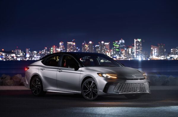 2025_Camry_XSE_AWD_HeavyMetalBlack parked in front of cityscape