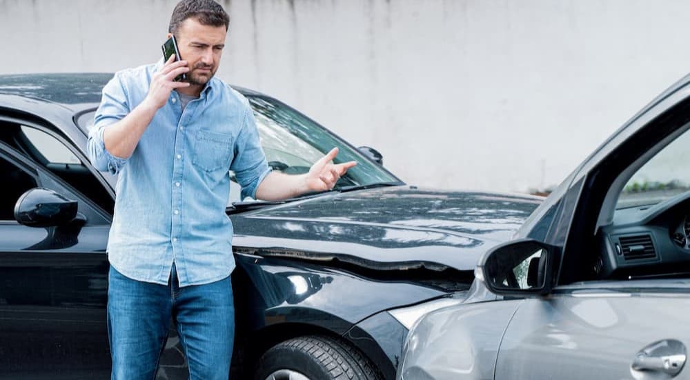 A person on the cellphone near a car accident.