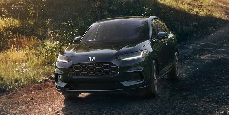 Black 2026 Honda HR-V driving down a gravel road.