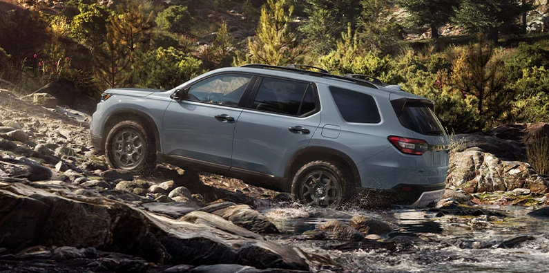 A 2025 Honda Pilot driving up a rocky hill.