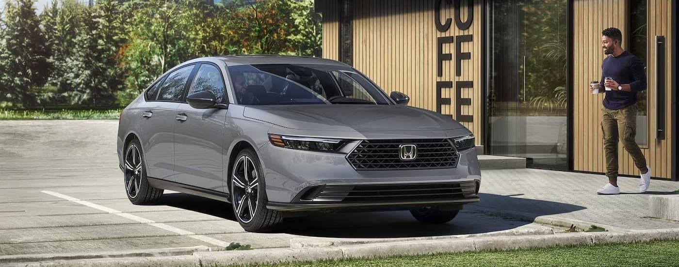 A gray 2026 Honda Accord Sport Hybrid parked near a coffee shop.