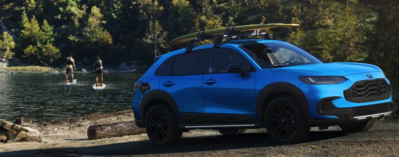 A blue 2027 Honda HR-V parked near a lake.