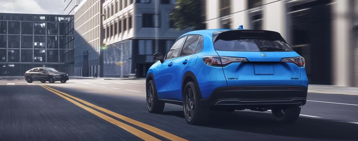 A blue 2027 Honda HR-V driving in a city.
