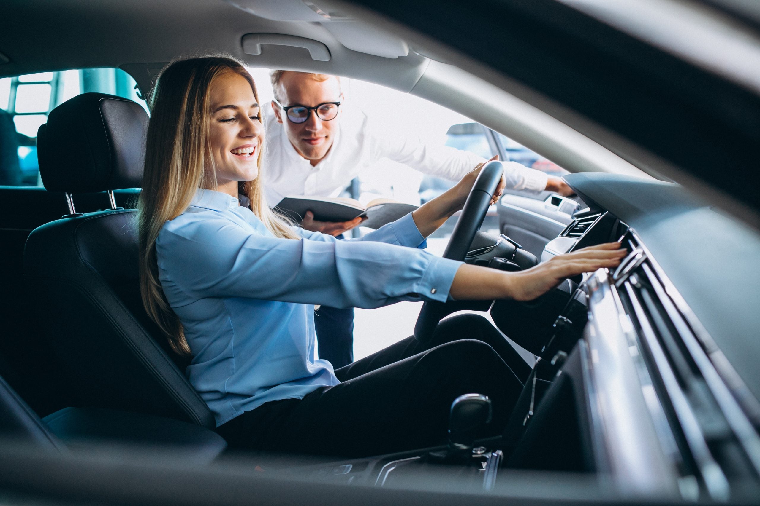 Young,Woman,Testing,A,Car,From,A,Car,Showroom