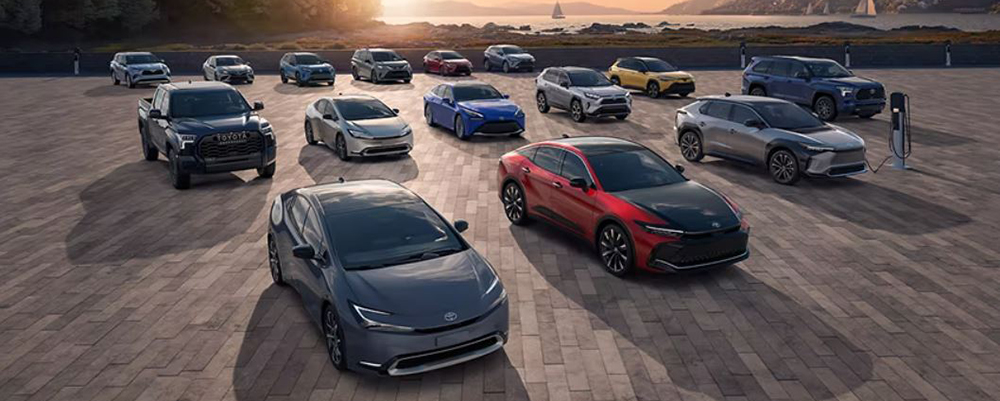 All bunch of Toyota Hybrid vehicles are parked across a large parking lot.