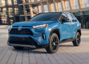 A blue Toyota RAV4, parked outside an office building.