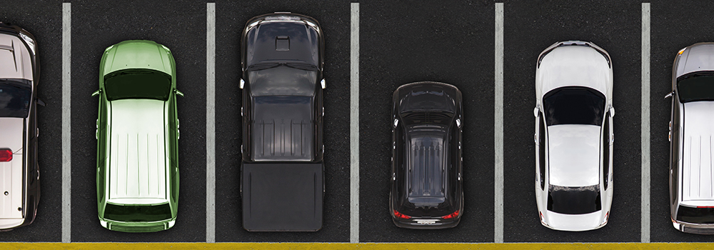 Overhead view of a variety of vehicles in a parking lot.