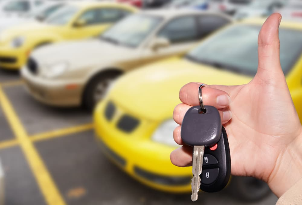 Thumbs up with yellow vehicles in the background