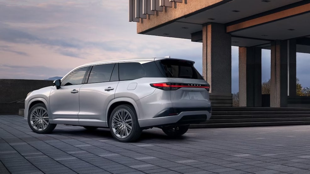 A silver 2026 Lexus TX SUV parked on a stone patio