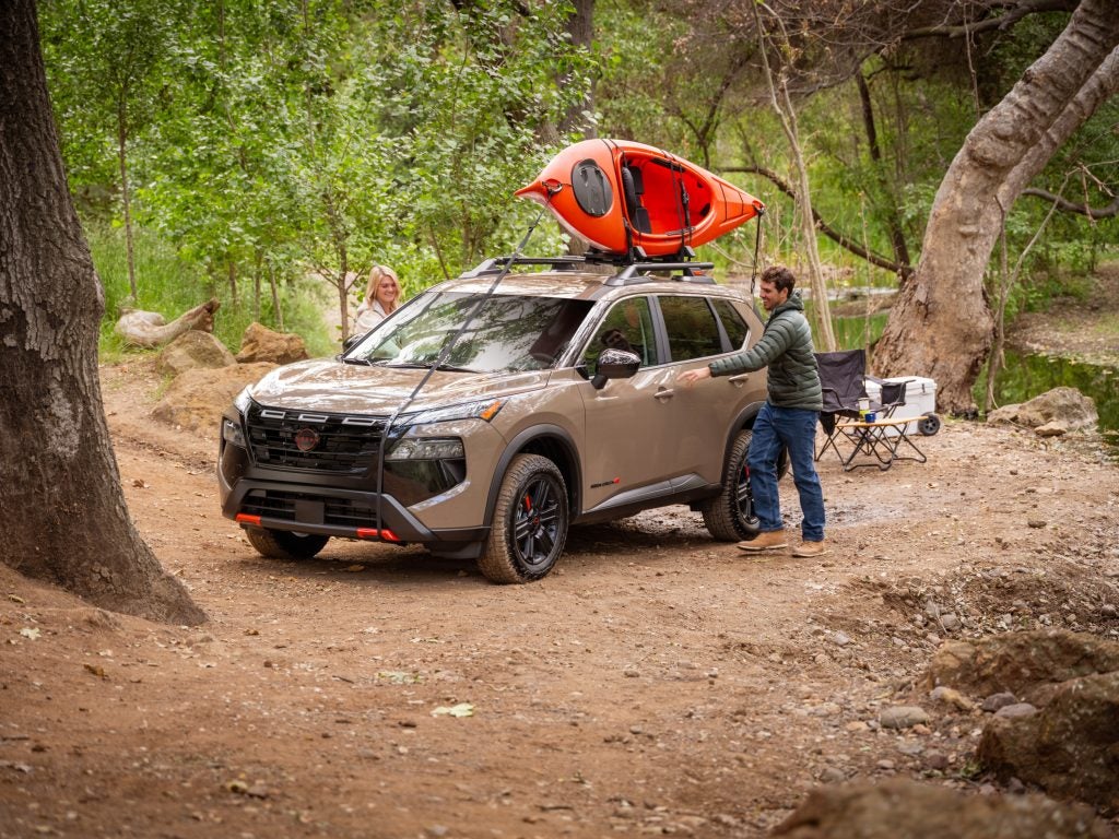 2025 Nissan Rogue Rock Creek trim with rugged styling, off-road tires, and unique grille parked in an adventurous outdoor setting.