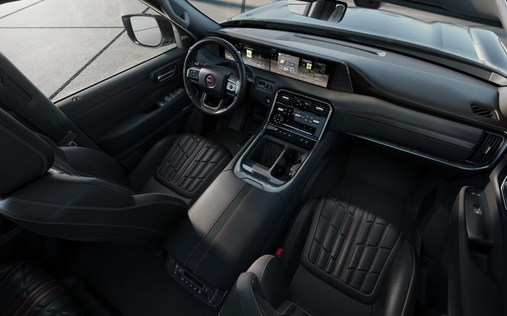 Luxurious interior of the 2025 Nissan Armada featuring quilted leather seats, dual digital displays, and advanced driver-assistance controls.
