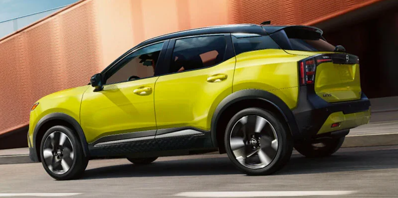 A Yellow 2025 Nissan Kicks driving down the street.