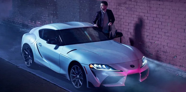 A man climbing in to the drivers side of a 2026 Toyota GR Supra