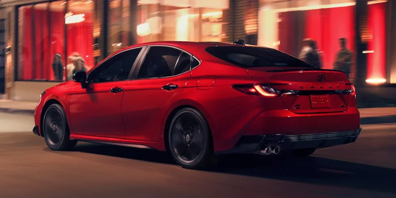 A red 2026 Toyota Camry driving down the road.