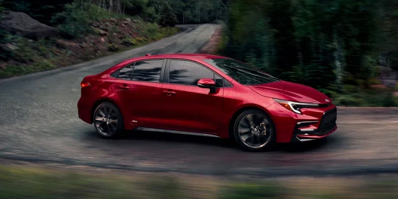 2025 Toyota Corolla-Hybrid driving down the road.