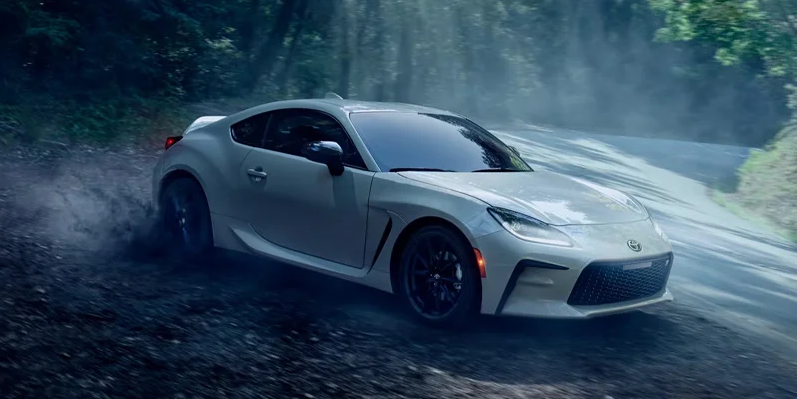 A photo of a 2025 Toyota GR86 parked on the side of a narrow road.