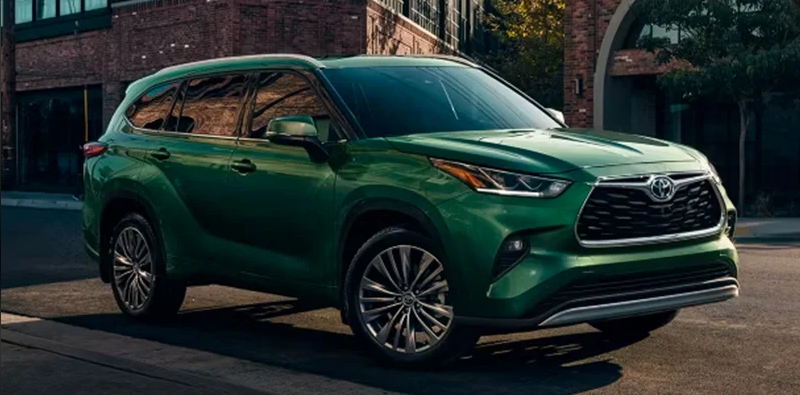 A green 2024 Toyota Highlander parked on the side of the road.