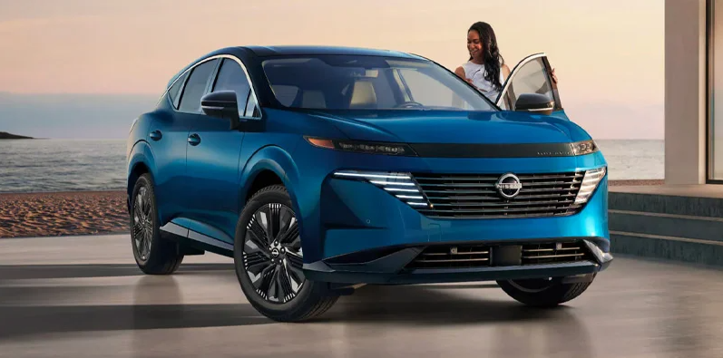 A woman climbing in to the drivers side of a blue 2025 Nissan Murano.