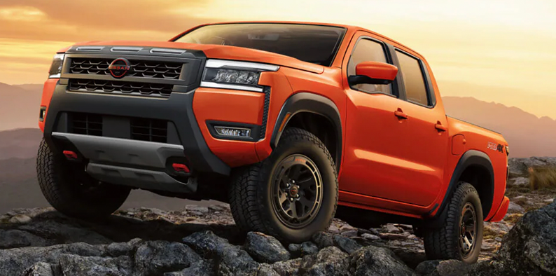 An orange 2026 Nissan Frontier off-roading. 