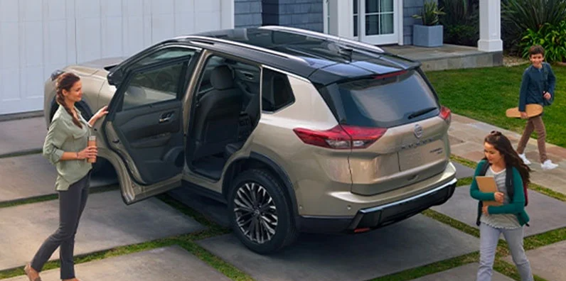 A woman and her kids climbing in to a 2025 Nissan Rogue.