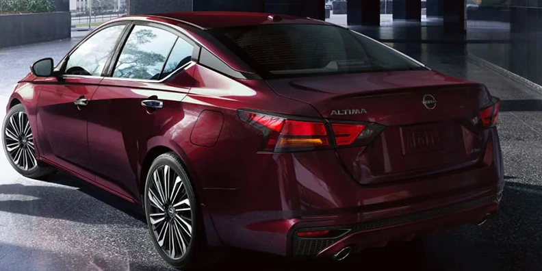 A photo of a red 2025 Nissan Altima making a left turn.
